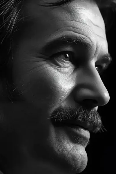 A dramatic black and white portrait of Burt Reynolds, capturing the complex legacy of the iconic Hollywood movie star.